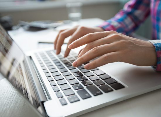 Cropped view of person hands typing on laptop computer